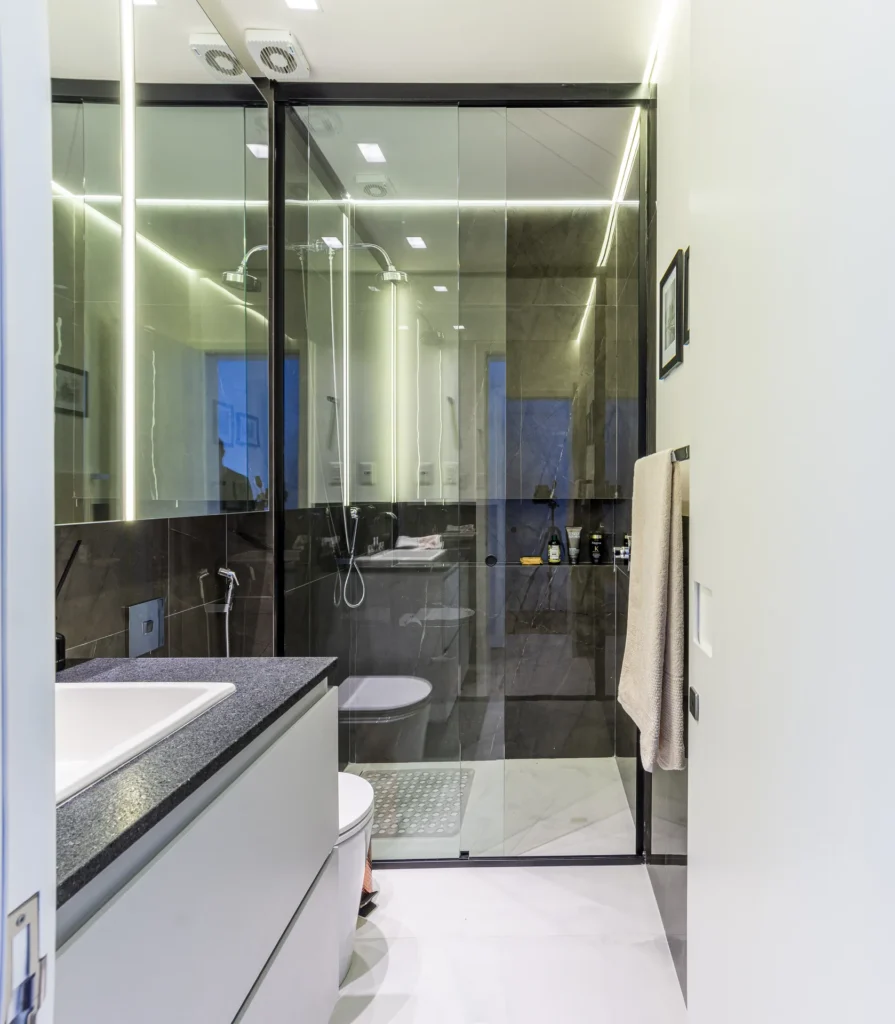 Banheiro com gabinete planejado e box em vidro com perfil preto