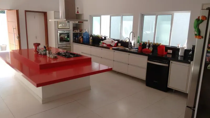 Cozinha planejada branca com ilha vermelha e torre quente