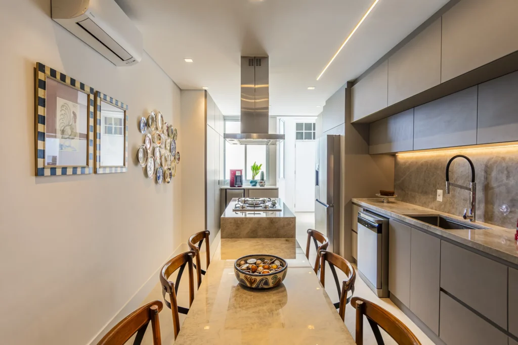 Cozinha integrada com mesa de jantar e armários planejados em tom fendi