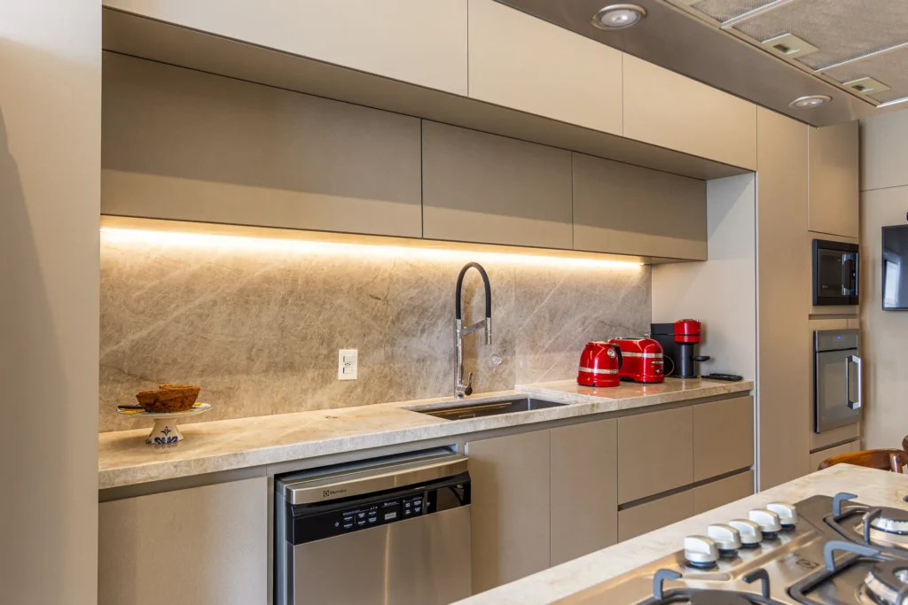 Cozinha planejada sob medida em MDF fendi com iluminação LED sob os armários aéreos