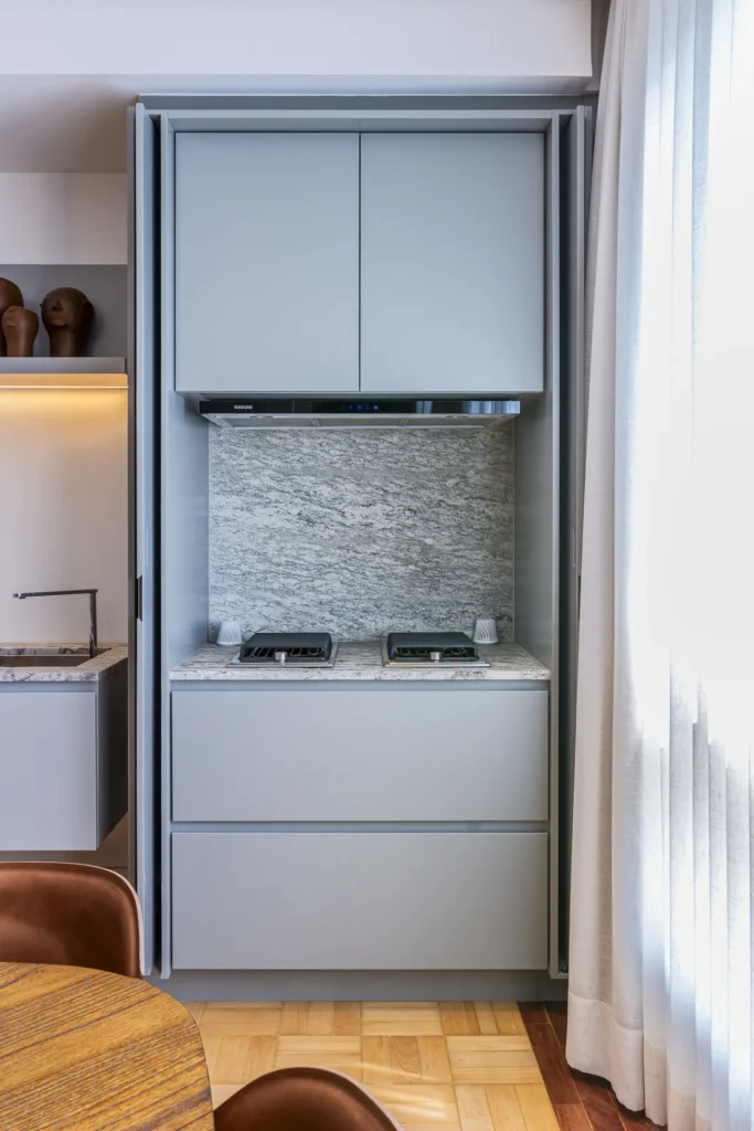 Copa embutida em armário planejado com cooktop e portas recolhíveis