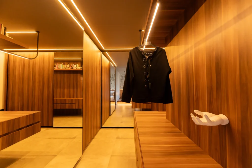 Closet aberto sob medida em madeira com cabideiro e bancada