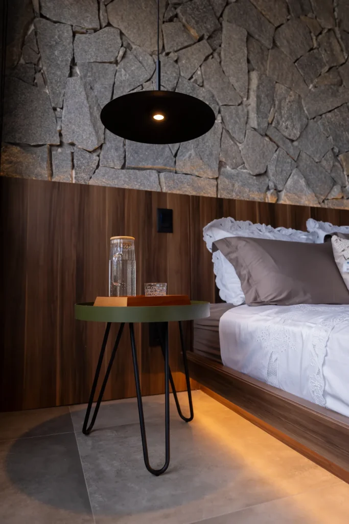 Detalhe de criado-mudo e cabeceira em madeira com iluminação indireta